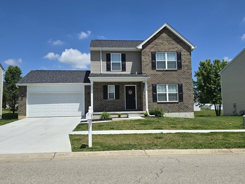 a brick house with a white garage and a driveway